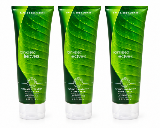 Bath & Body Works RAINKISSED LEAVES Ultimate Hydration Body Cream 3-Pack 8 oz tubes featuring a fresh green botanical fragrance inspired by rain-kissed leaves with Shea Butter and Hyaluronic Acid on a pure white background for online shopping and gifting