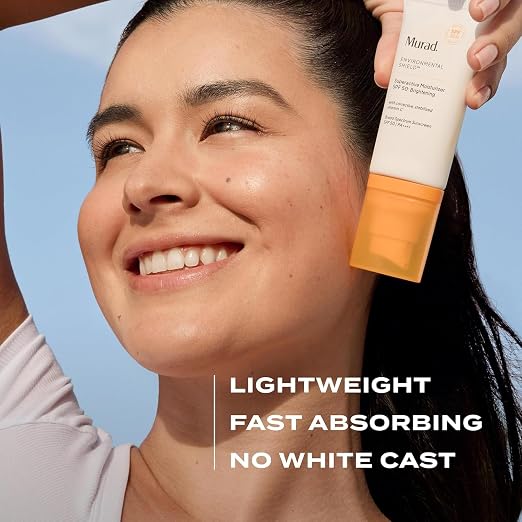 Woman applying MURAD Superactive Brightening Moisturizer SPF 50 with a blue sky background