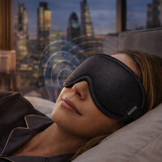 Woman wearing sleep mask relaxing in bed at night for deep sleep and stress relief wellness routine MWG