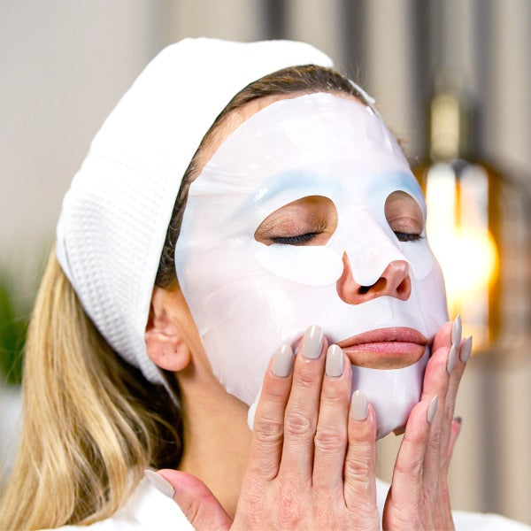 Woman using Snow Lotus bio-cellulose face mask for deep hydration and glowing skin