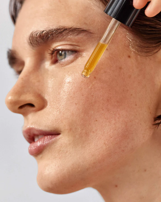 Woman applying True Botanicals Chebula Active Serum as part of a luxury clean beauty skincare routine for glowing hydrated skin
